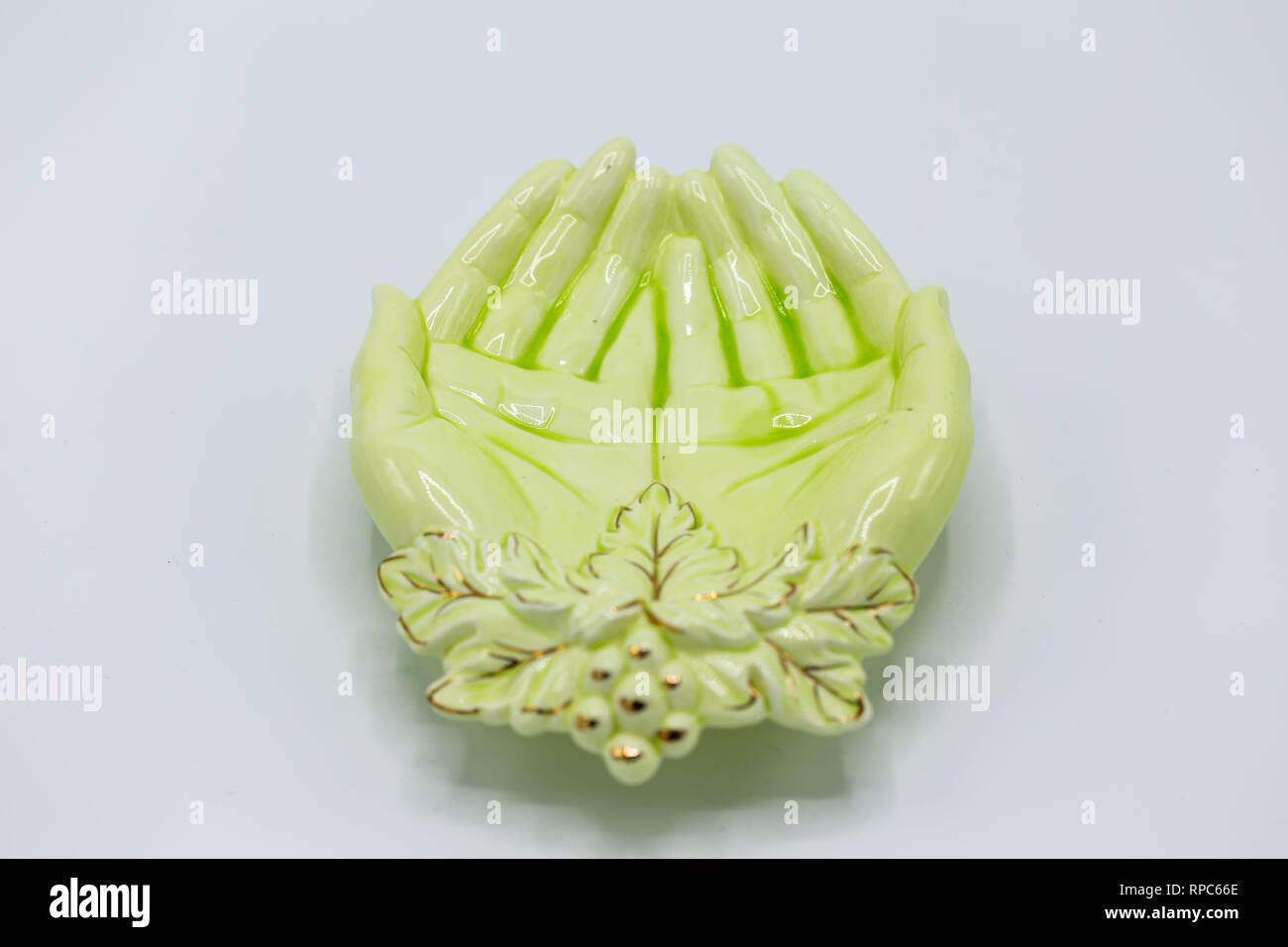 a small green dish in the shape of two cupped hands Stock Photo