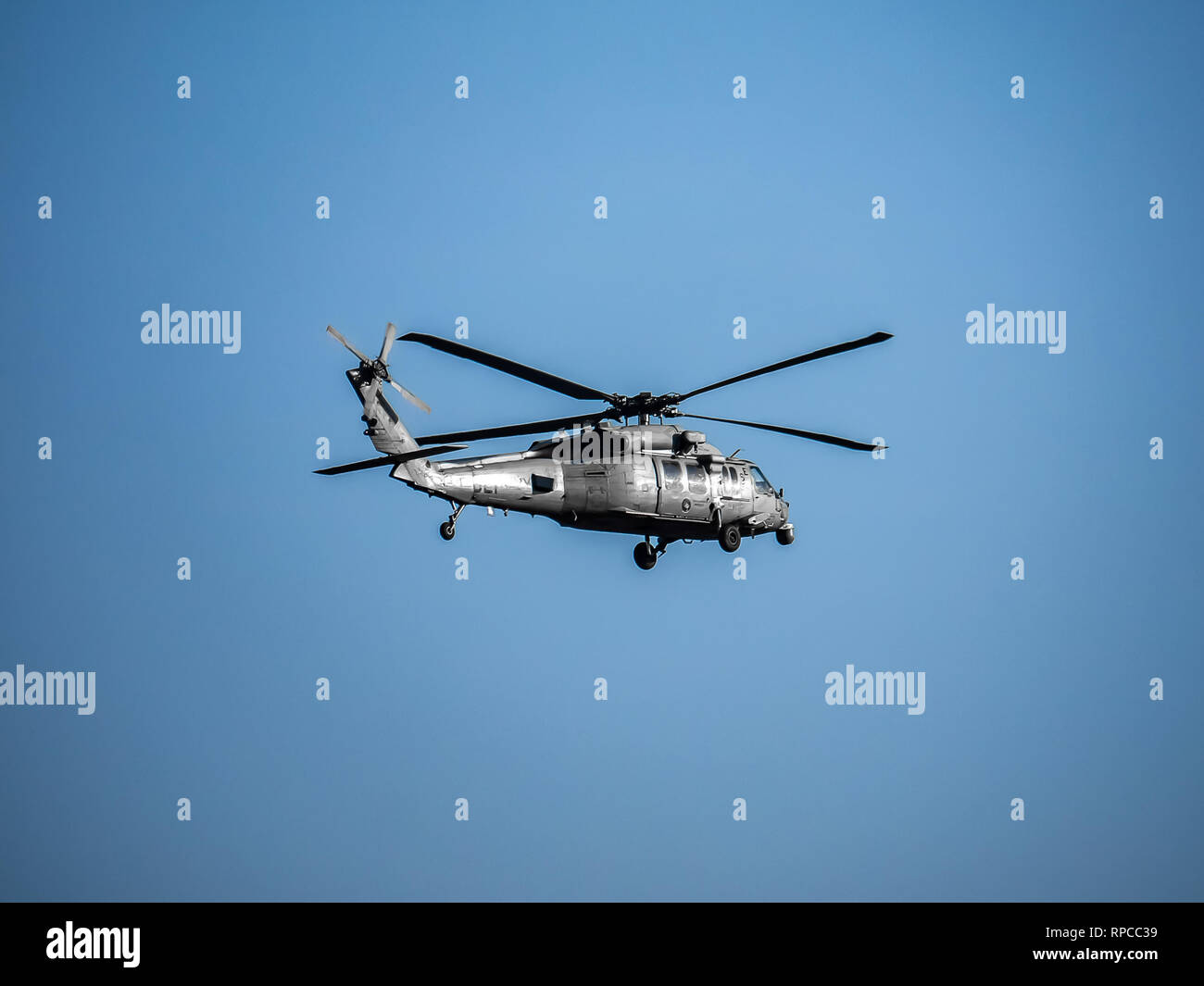 A U.S. Navy SH-60 helicopter flying patrol during flight operations on Naval Air Station Atsugi in Kanagawa, Prefecture Japan. The shared facilities a Stock Photo