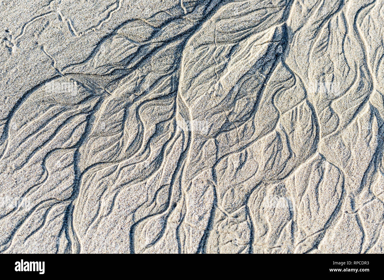 Beach patterns caused by the retreating tide. Stock Photo