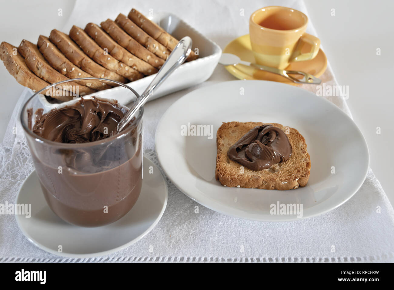 fette biscottate con crema di nocciole al cacao con bicchiere da sopra Stock Photo