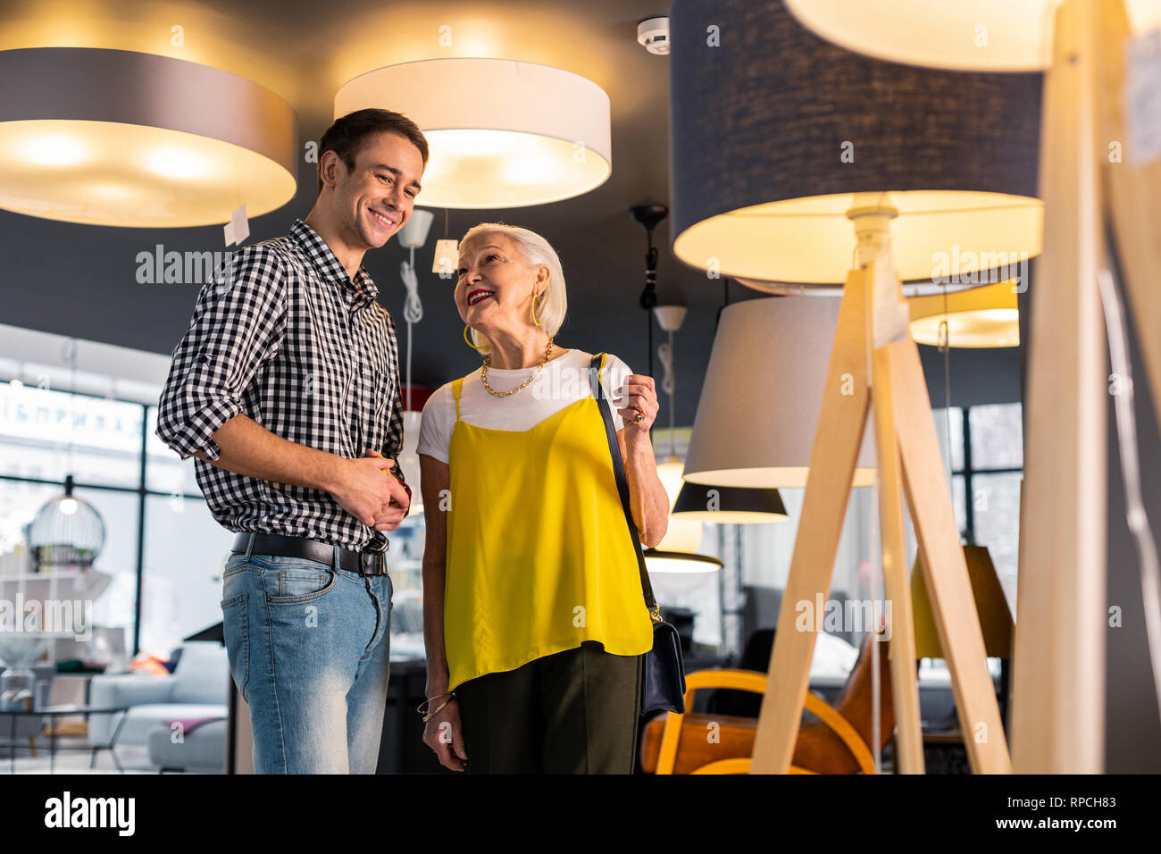 Happy stylish aging mother looking affectionately at adult handsome son Stock Photo