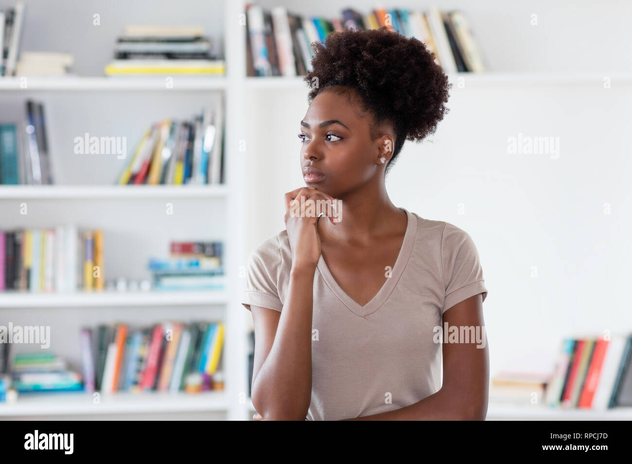 Thinking african american young adult woman indoors at home Stock Photo