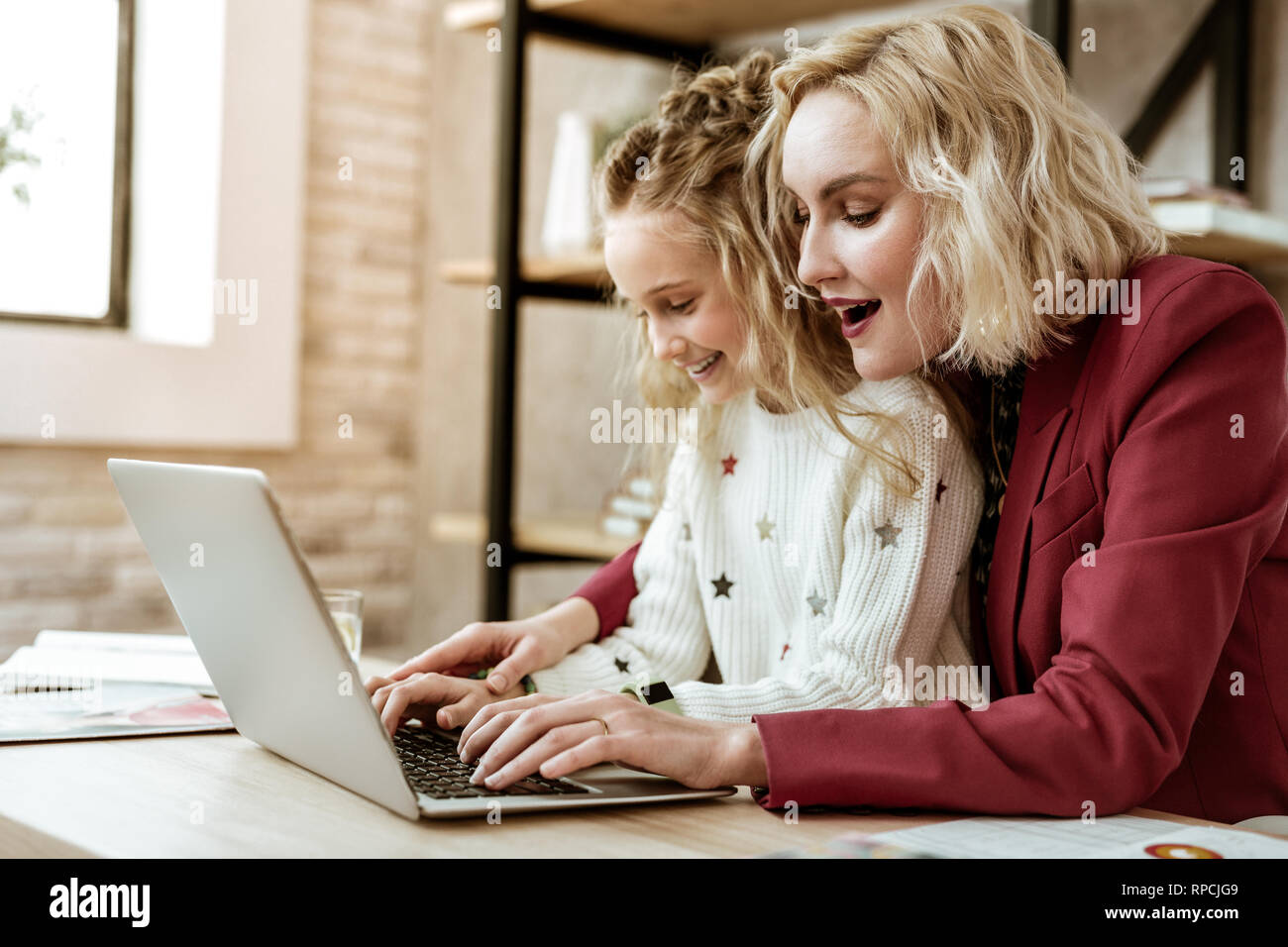 Positive amused blonde woman being happy with her daughter progress Stock Photo
