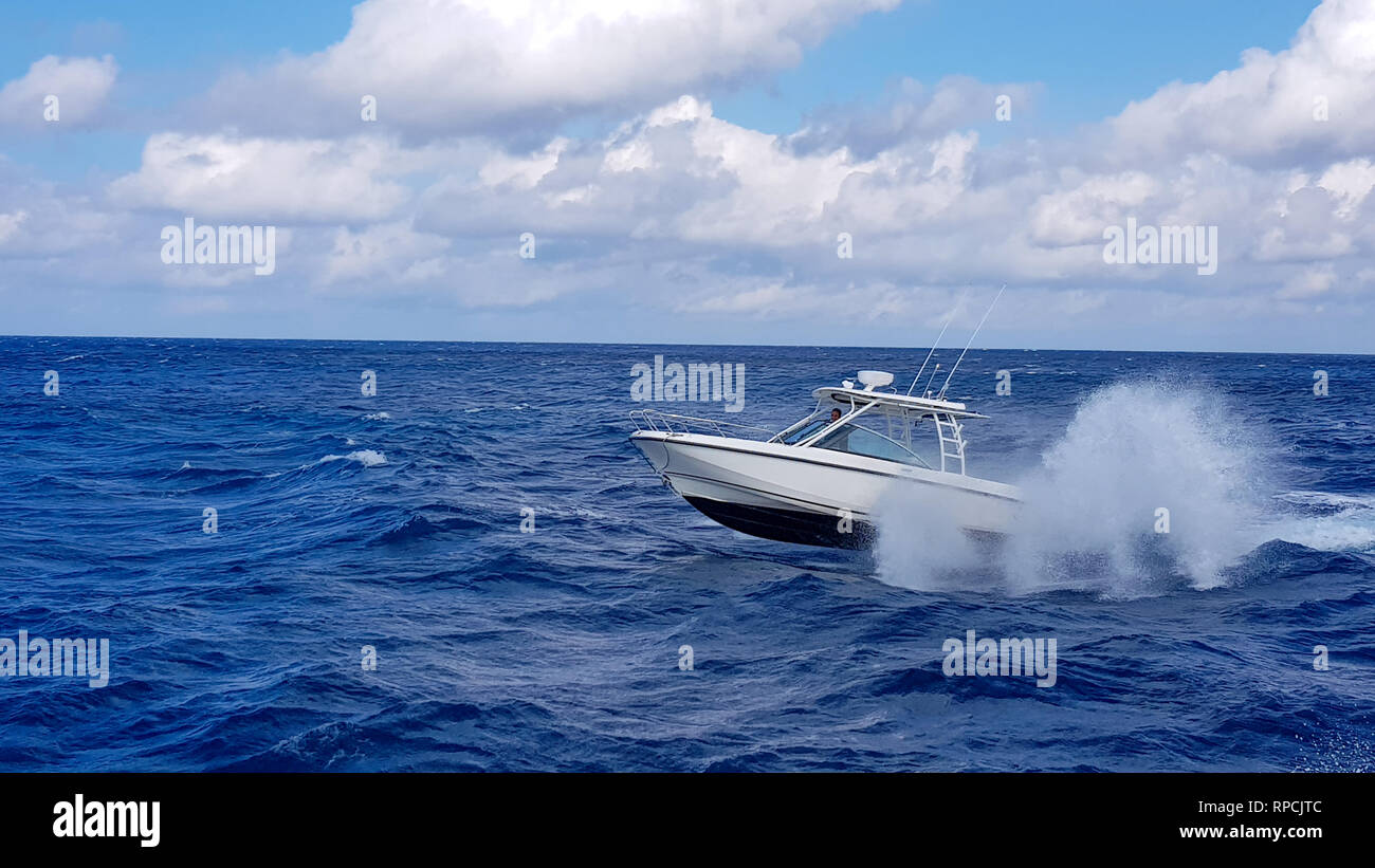 Speed fishing tender boat jumping the waves in the sea and cruising the blue ocean day in Bahamas. Blue beautiful water Stock Photo