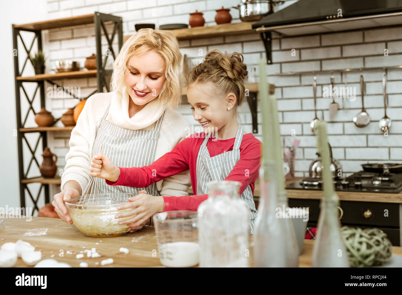 Smiling mother with clean makeup carrying glass bowl Stock Photo