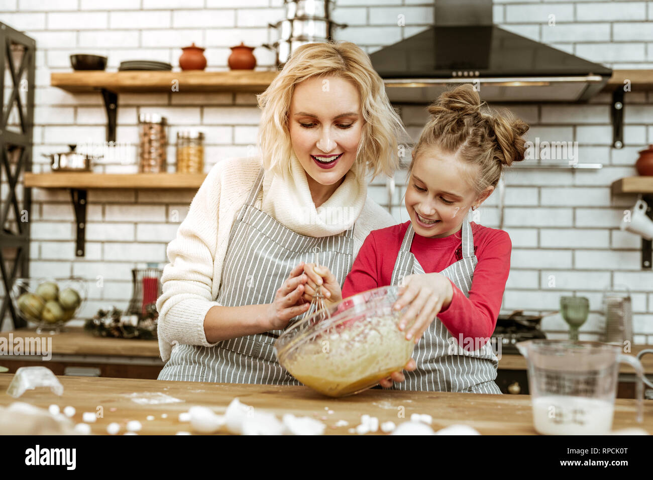 Smiling appealing woman being happy with her cooking daughter Stock Photo