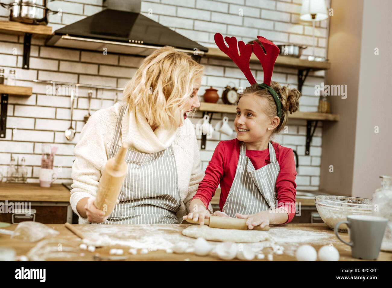 Amused short-haired woman looking on happy daughter Stock Photo