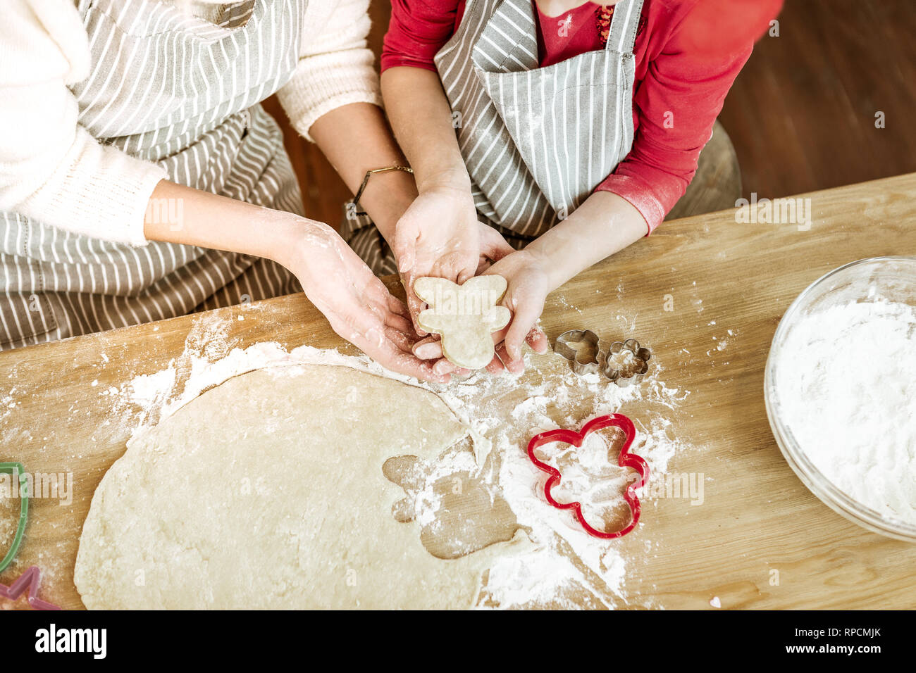 Positive little child carrying unready cookie with her little hands Stock Photo