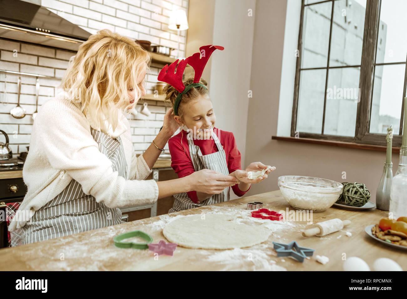 Beaming blonde woman praising her little daughter for good job Stock Photo