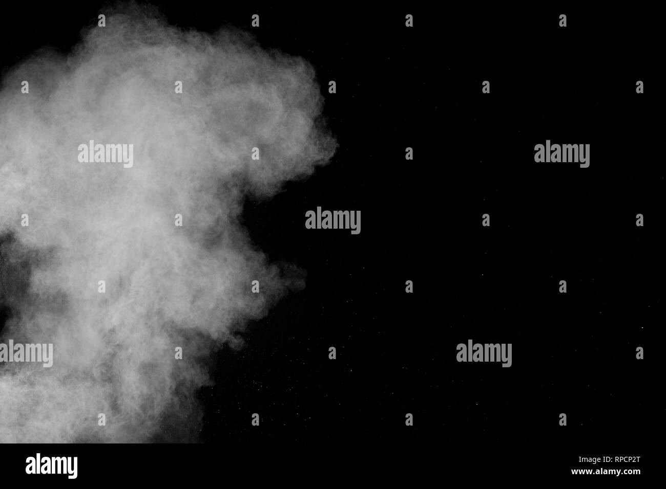 Bizarre forms of white powder explosion cloud against black background.White dust particles splash. Stock Photo