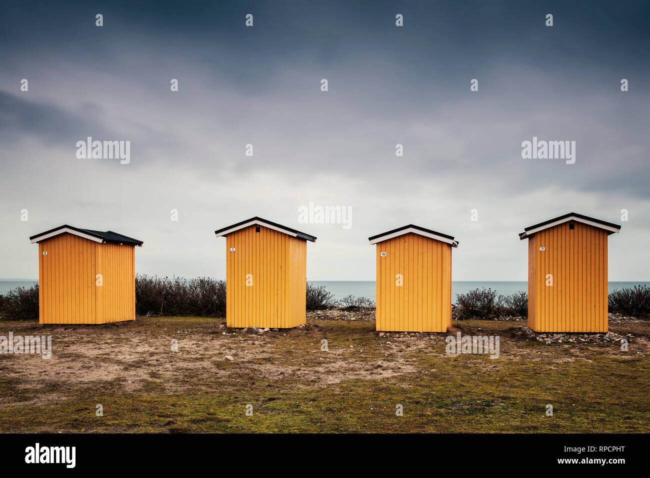 Yellow wooden beach huts. Viken, Sweden. Stock Photo