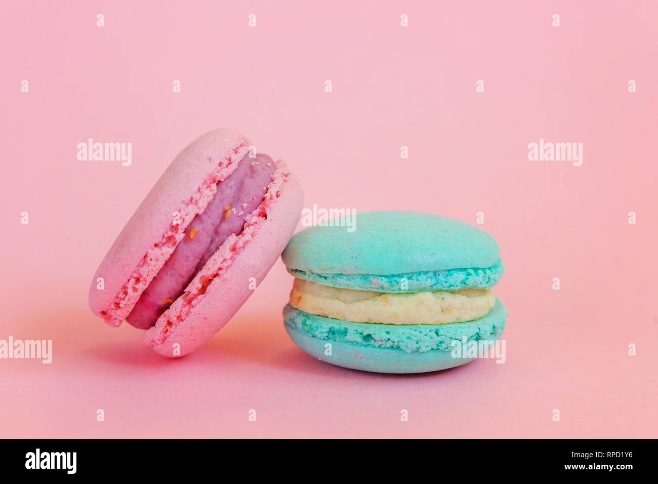 Sweet almond colorful unicorn blue pink macaron or macaroon dessert cake isolated on trendy pink pastel background. French sweet cookie. Minimal food  Stock Photo