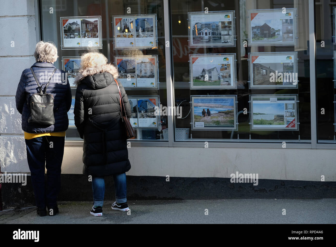 Two women looking in an estate agents window in Falmouth, Cornwall. Stock Photo