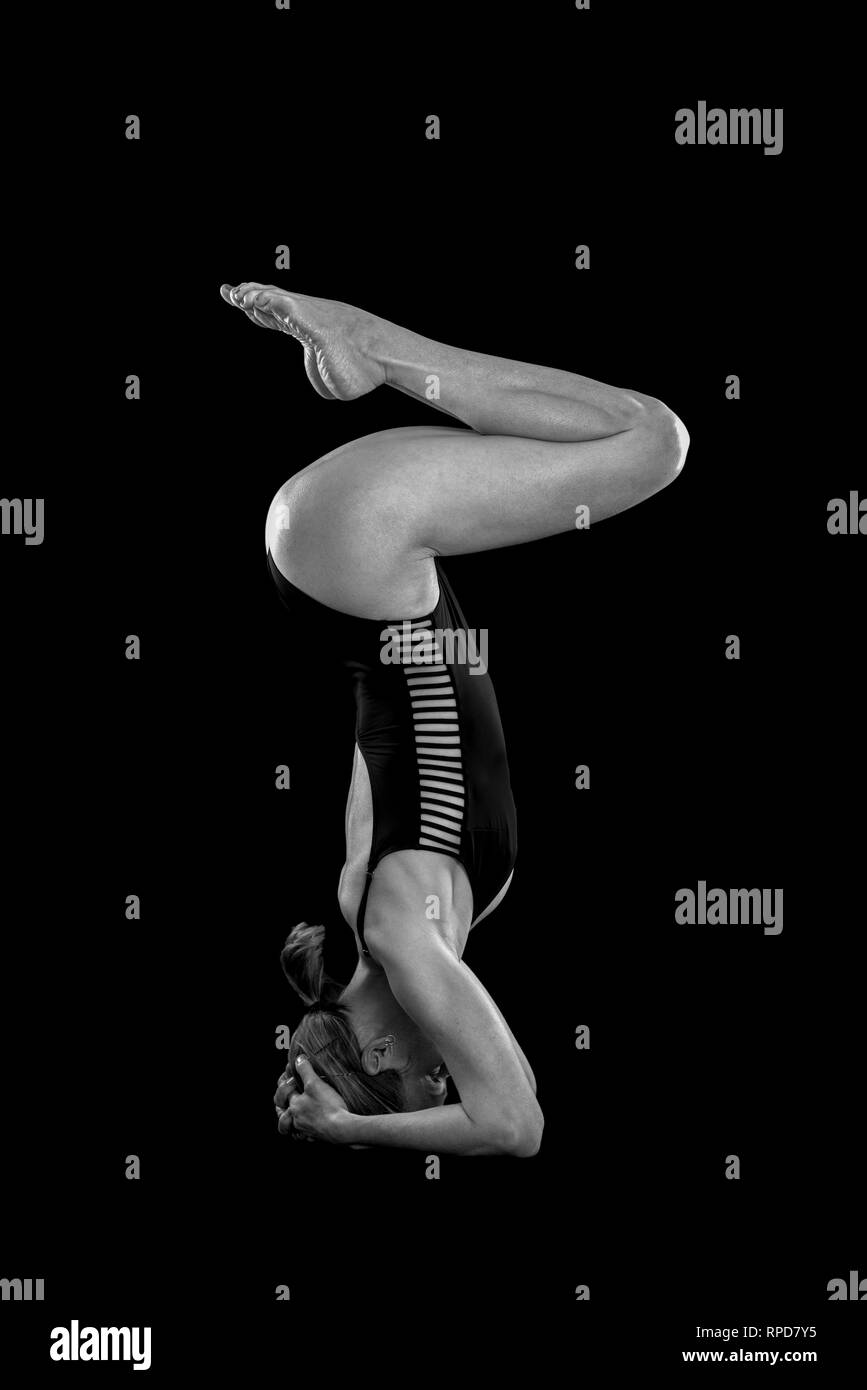 woman practicing yoga, headstand in the studio, black & white Stock Photo