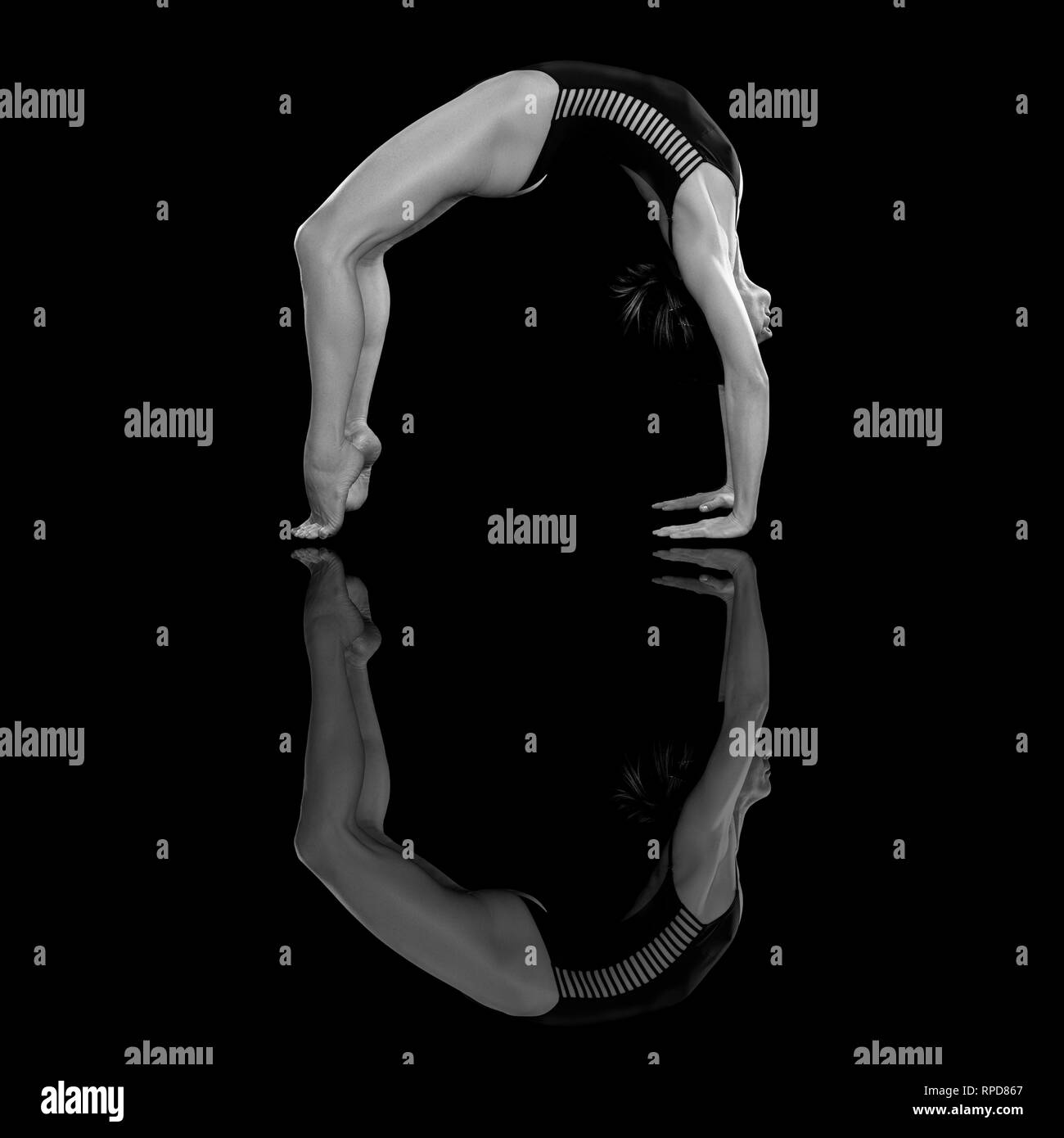 woman practicing yoga, 'wheel' pose in the studio, black & white Stock Photo