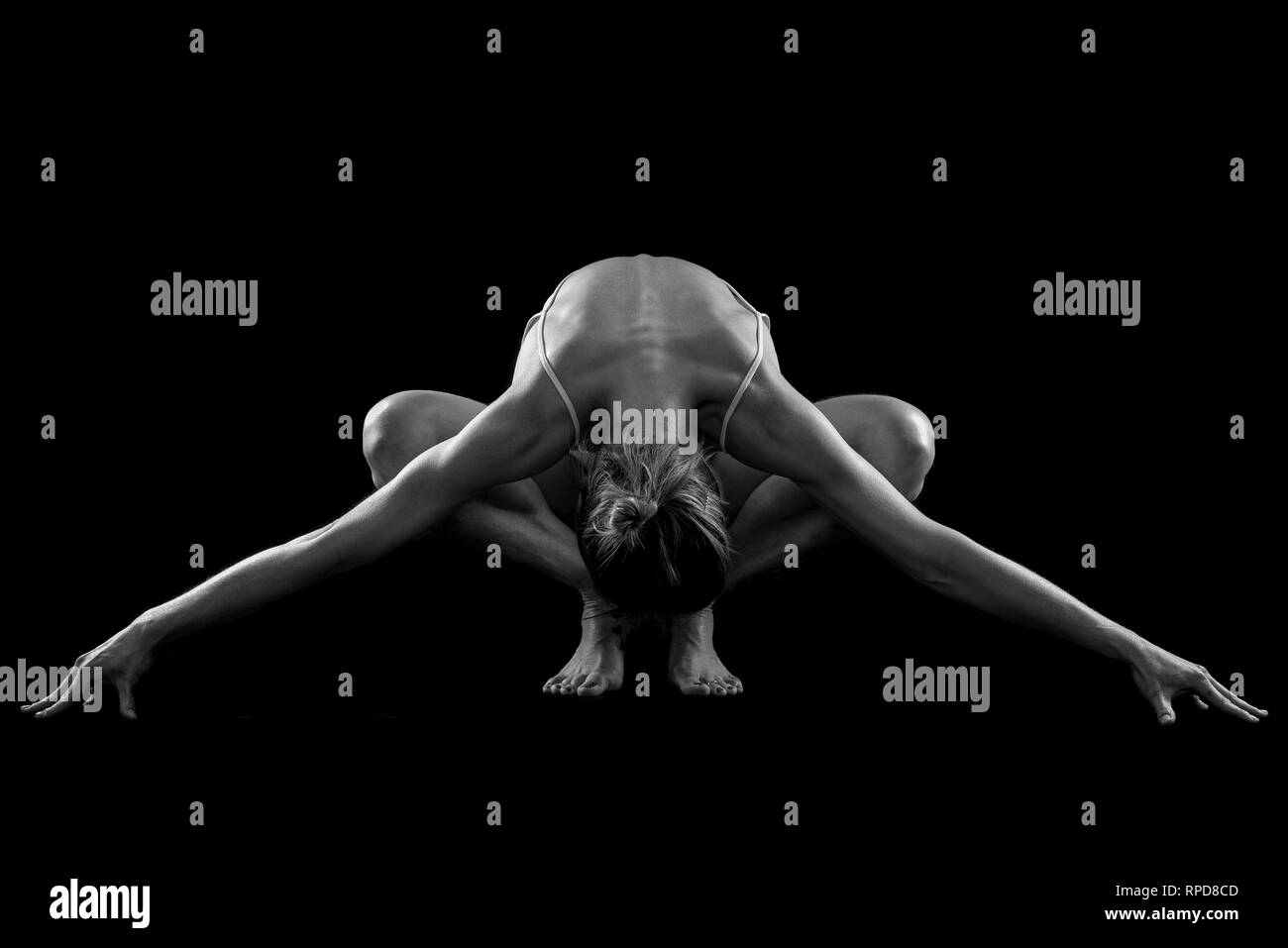 woman practicing yoga, 'squat' pose in the studio, black & white Stock Photo