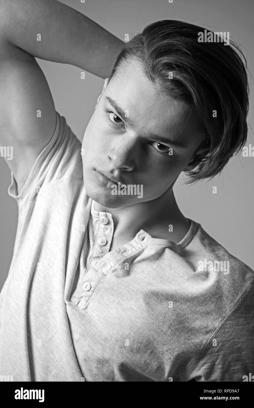 Guy On Confident Face In Light Shirt Touches Hair Grey Background
