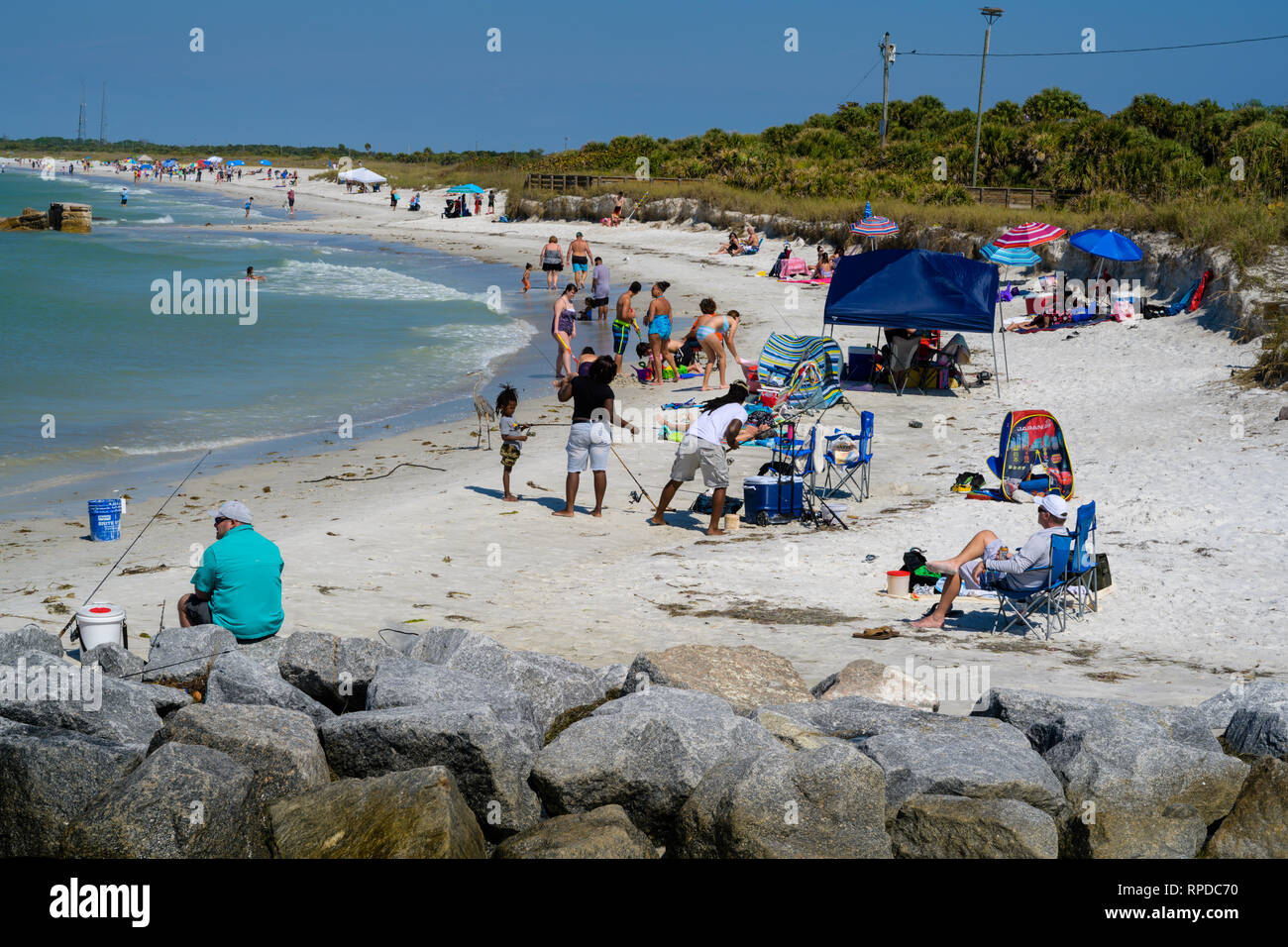 Fort De Soto Park, Florida -- February 17, 2019.  Photo of a very busy beach populated by a diverse crowd of fishermen, swimmers and sunbathers. Stock Photo