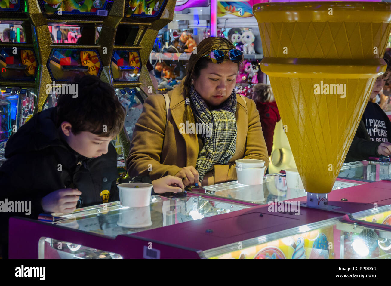 A mother and son play two penny falls in an amusement arcade in Bournemouth, Dorset, UK Stock Photo