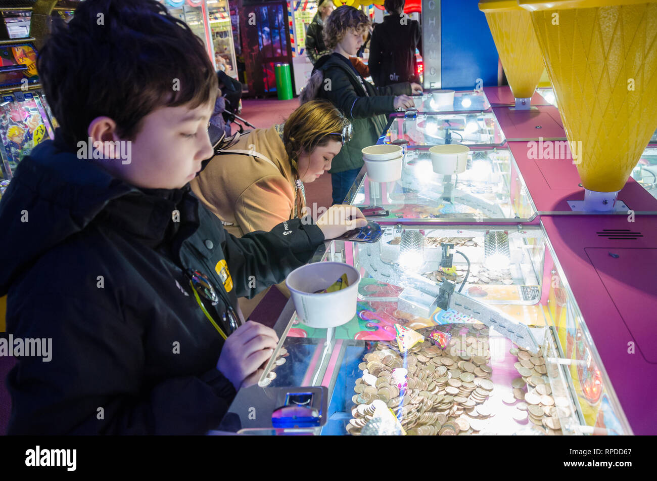 A mother and son play two penny falls in an amusement arcade in Bournemouth, Dorset, UK Stock Photo