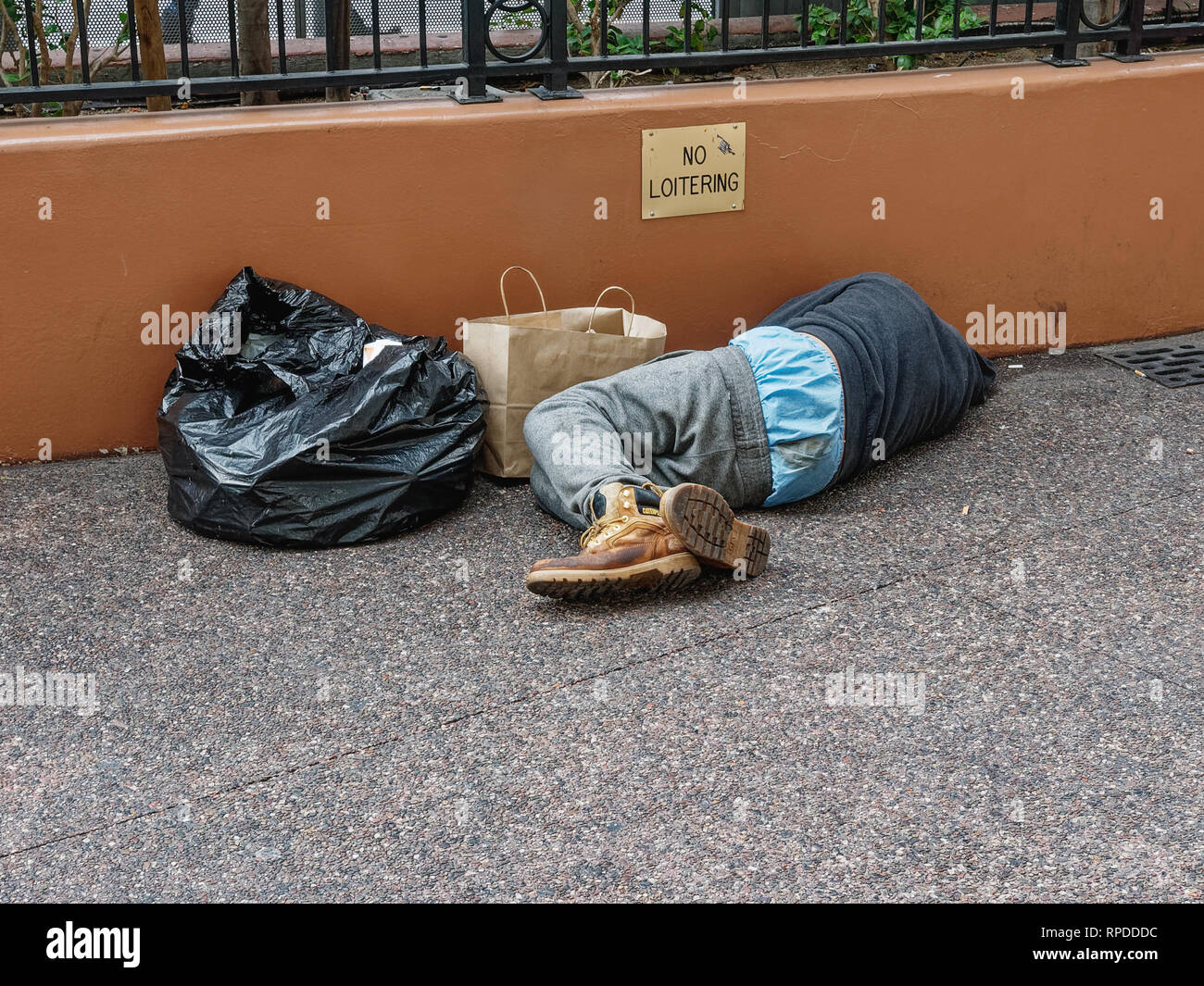 Las Vegas, Nevada -  November 21, 2016: Homeless person is sleeping on 'the strip' in front of a 'No Loitering' sign. Stock Photo