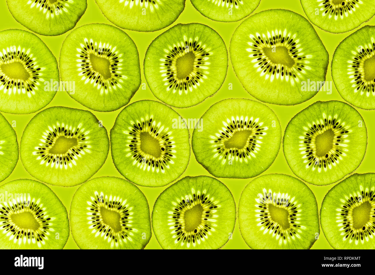 Kiwi slices illuminated from below Background Fruits Top view Stock Photo