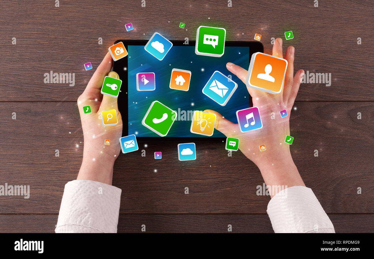 Hand using tablet with colourfull bounce application symbols and icons ...