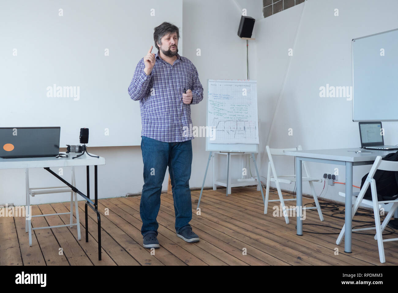 Experienced worker consulting new specialists. Creative person talking to audience. Speaking to audience in classroom, lecturing hall. Supervisor Stock Photo