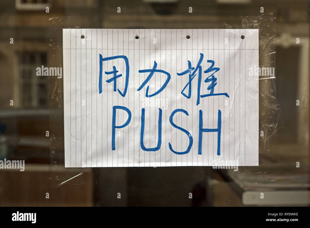 Handwritten sign in Chinese and English with the word Push on the door of a Chinese takeaway in Edinburgh, Scotland, UK. Stock Photo
