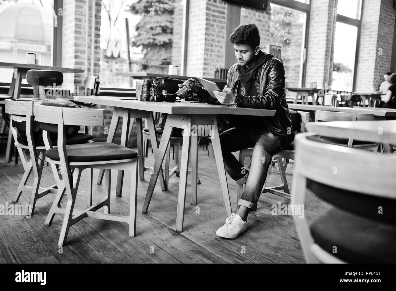 Smart young asian man photographer working with tablet during sitting at cafe. Stock Photo