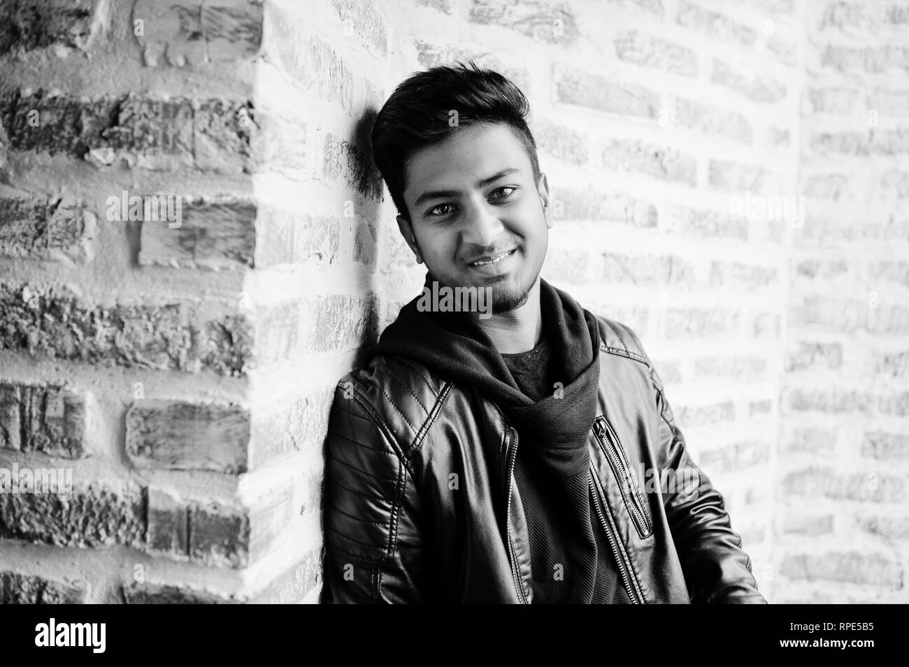 Smart young asian man wear on leather jacket posing against brick wall. Stock Photo