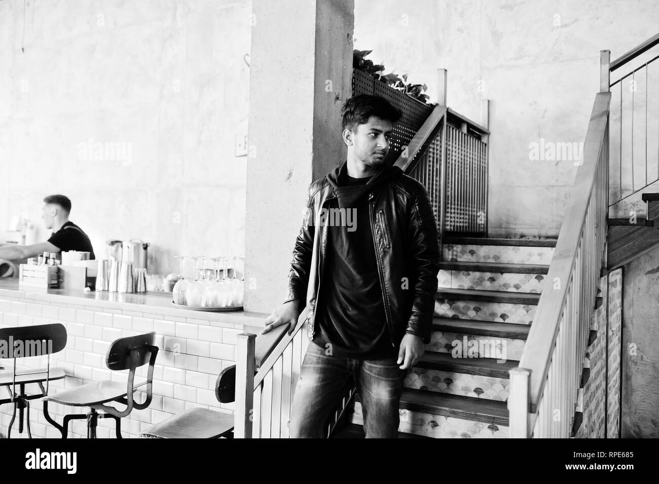 Casual and stylish young asian man wear on leather jacket standing on stairs at cafe. Stock Photo