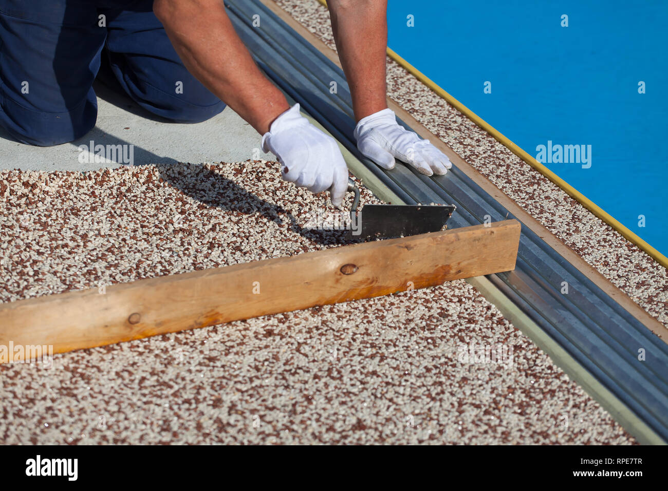 The worker places a stone carpet with resin.  (Shallow DOF). Stock Photo