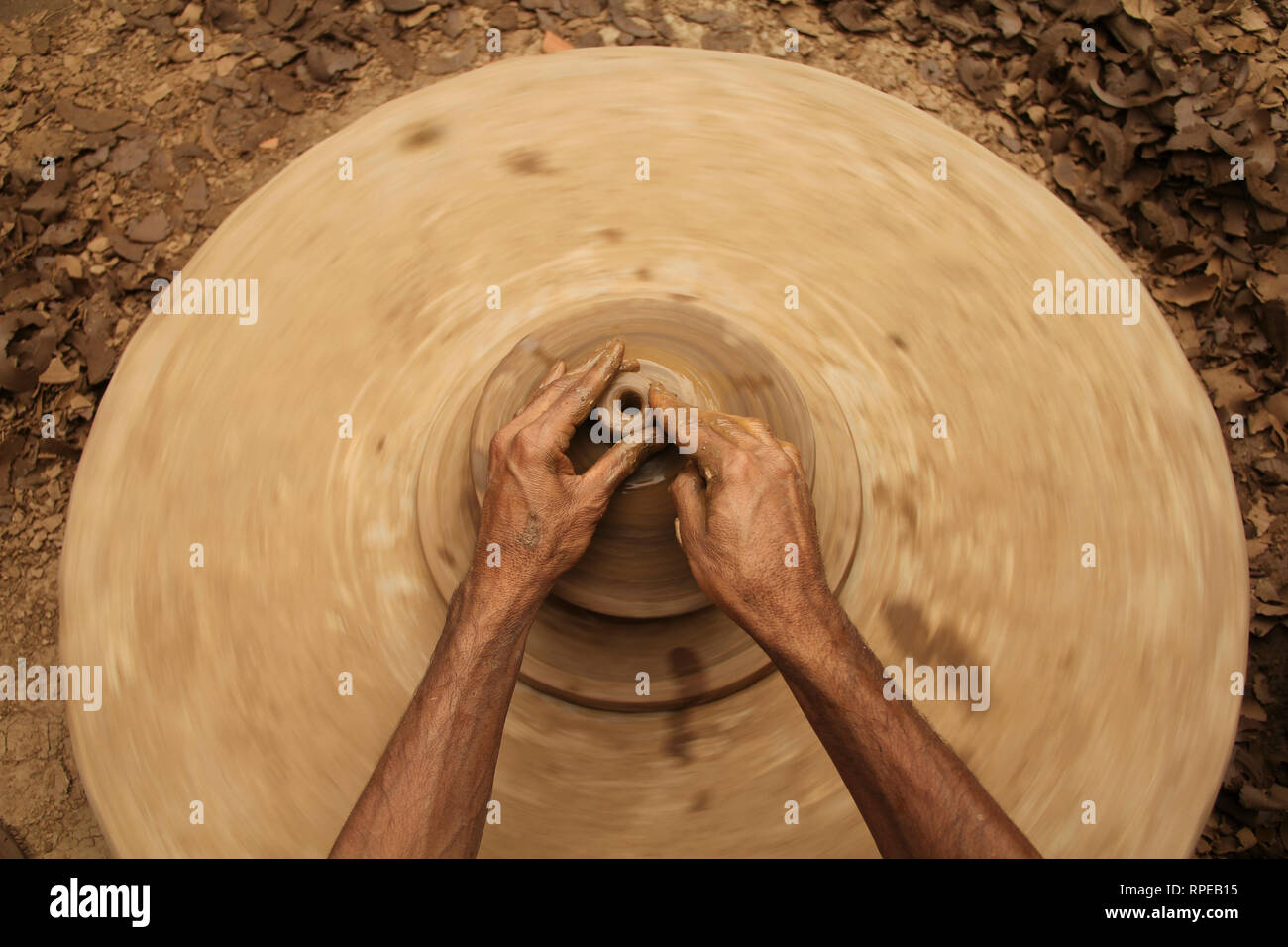 Kashmiri potter works with mud to make an earthen pot at a village in Budgam Kashmir Stock Photo