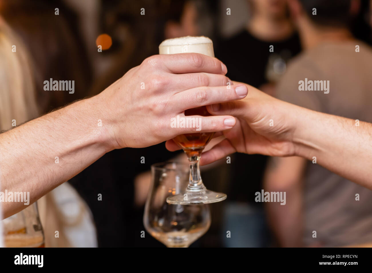 picture of the hand of an innkeeper who delivers a drawn glass of beer Stock Photo