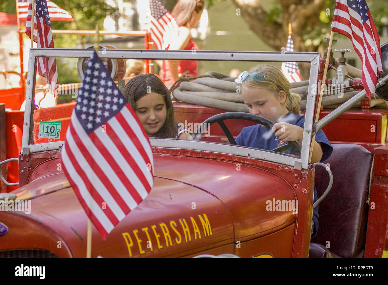Two kids in an old firetruck at a July 4th Parade in Petersham