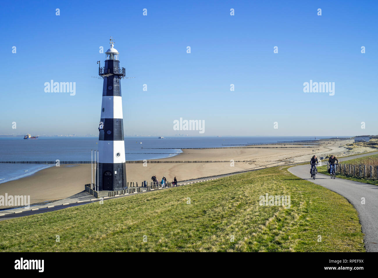 Levee / dike and Nieuwe Sluis, lighthouse near Breskens which marks the entrance to the Western Scheldt / Westerschelde, Zeeland, the Netherlands Stock Photo