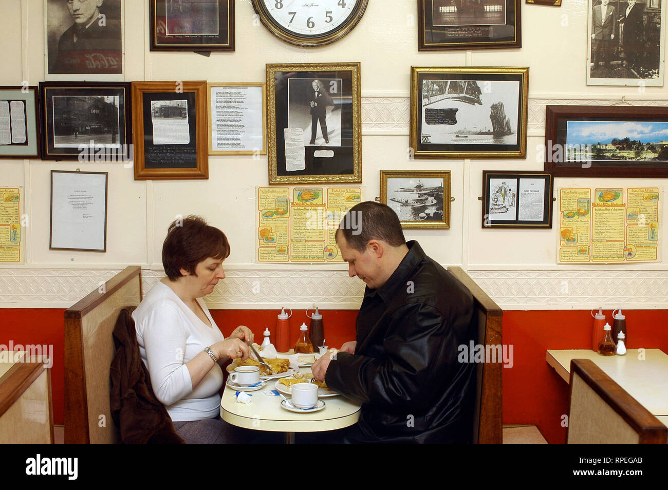 A couple eating at 'The Val D'oro', the oldest Fish & Chips store in Glasgow, Scotland, United Kingdom Stock Photo