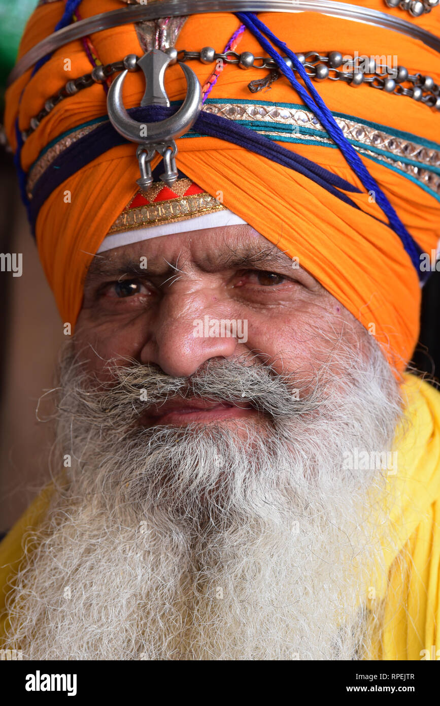 Colourful, turbaned man in the Guru ka Langar, a free Sikh kitchen where all visitors are fed a simple holy meal, Amritsar, Punjab, India, Asia. Stock Photo