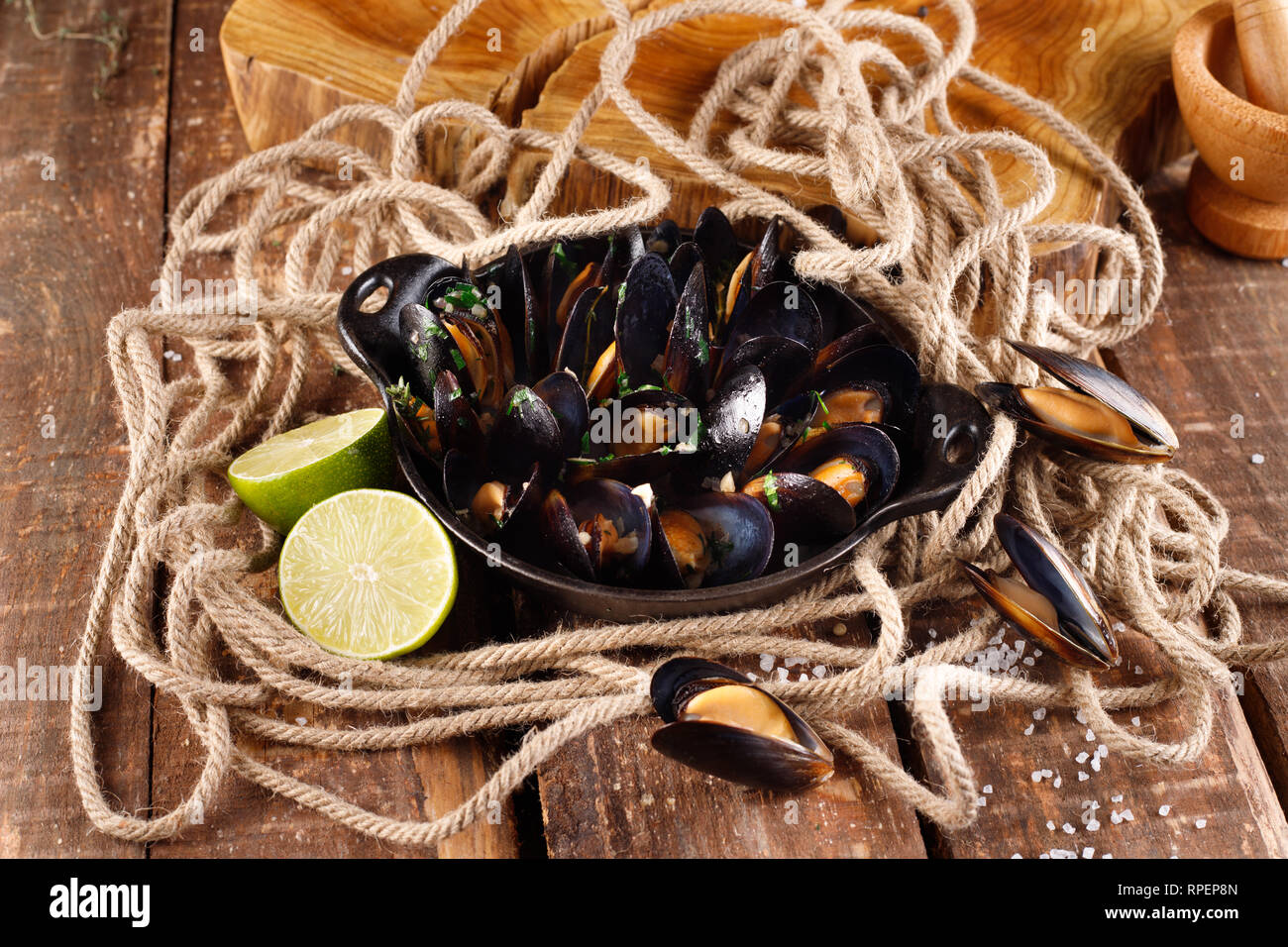 Boiled mussels in copper dish for cooking on wooden background close-up Stock Photo