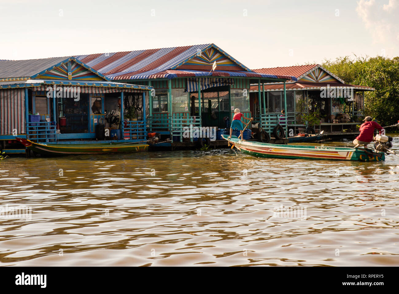 Father and son docking boat on the Vietnamese Cambodian floating village river of Chong Khneas on the Tonle Sap Lake in Cambodia. Stock Photo