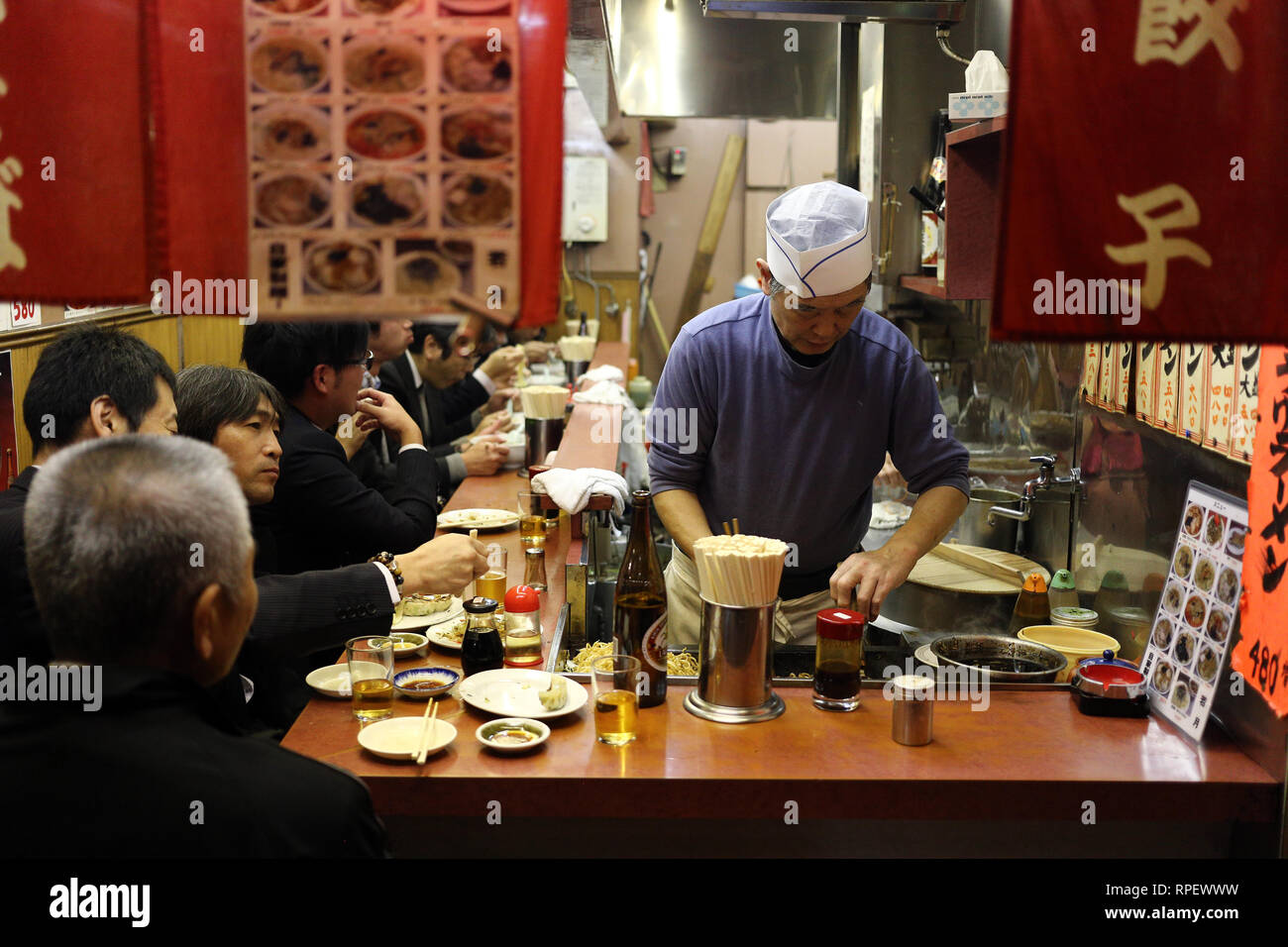TOYKO, JAPAN - DECEMBER 05, 2016: Unidentified japanese cheff preparing the dishes for his clients in a restaurant in Shinjuku area in Toyko, Japan Stock Photo