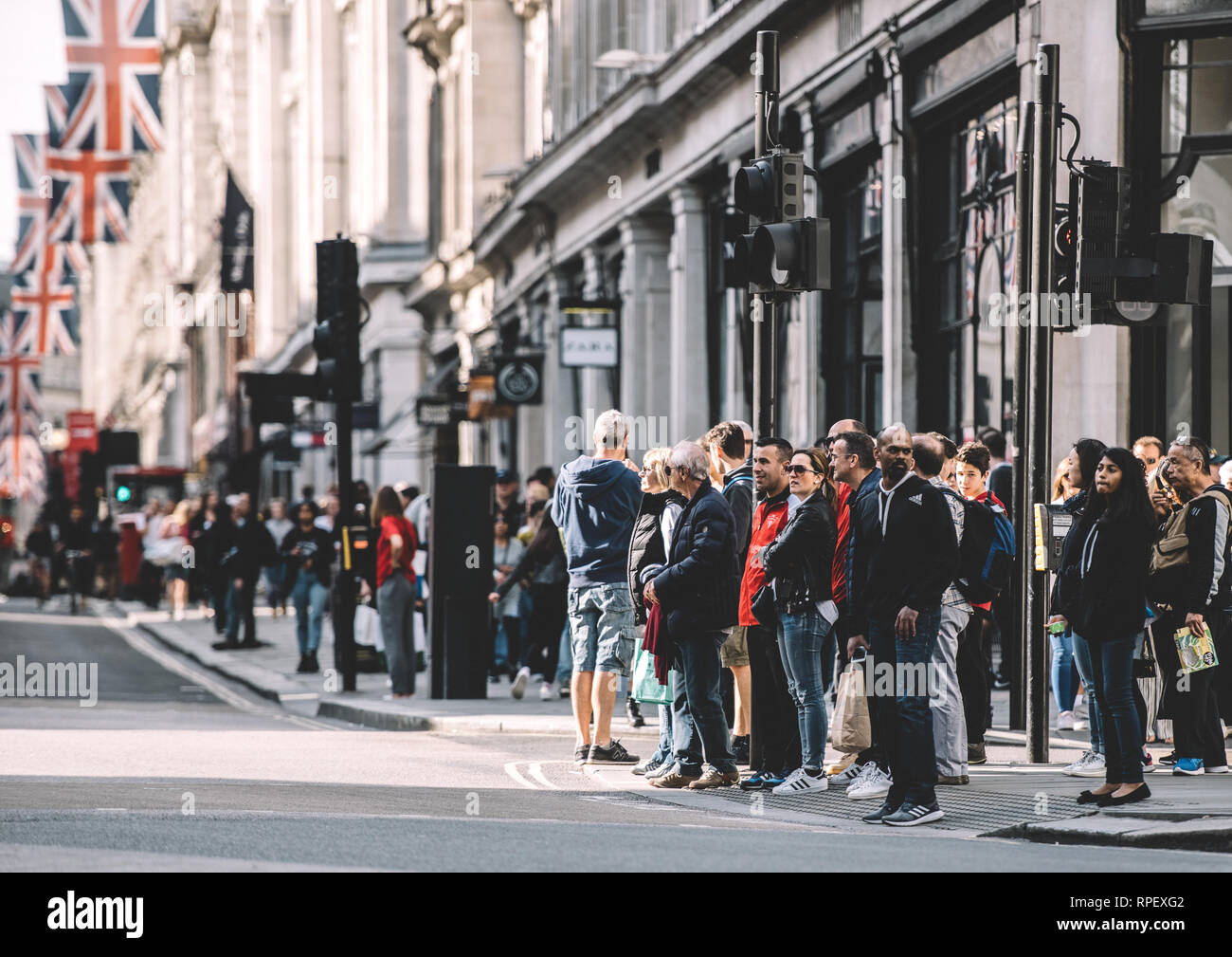 LONDON, UNITED KINGDOM - MAY 18, 2018: Pedestrians waiting to cross the Regent Street in London on a warm spring day  Stock Photo