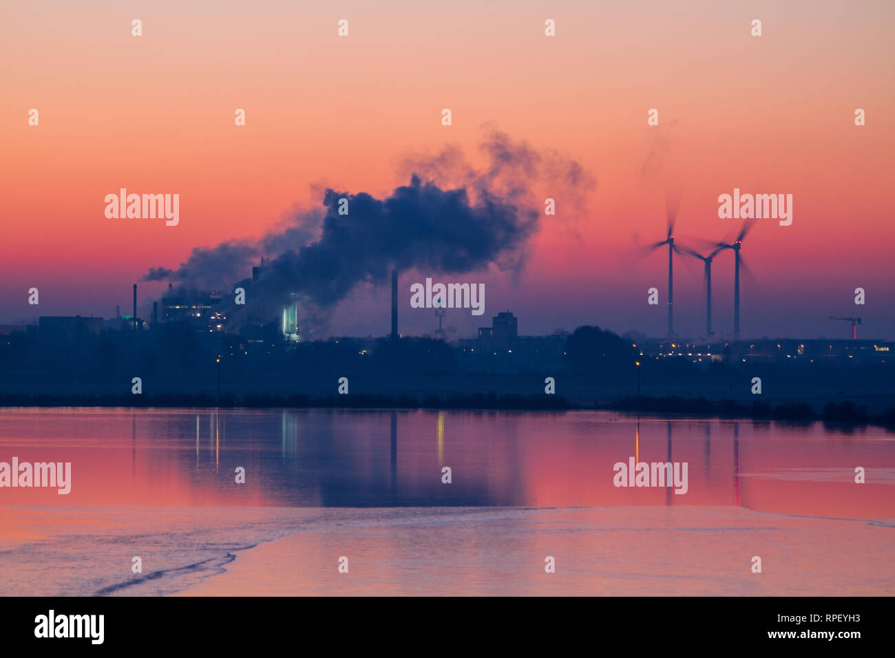 Colorful sunrise with industry buildings and wind turbines Stock Photo