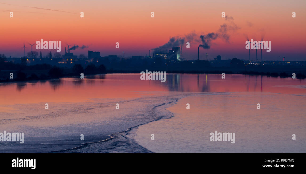 Panorama of industry buildings and wind turbines at sunrise Stock Photo