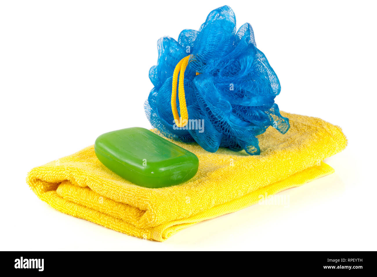 Yellow towel with blue bath sponge and soap isolated on white