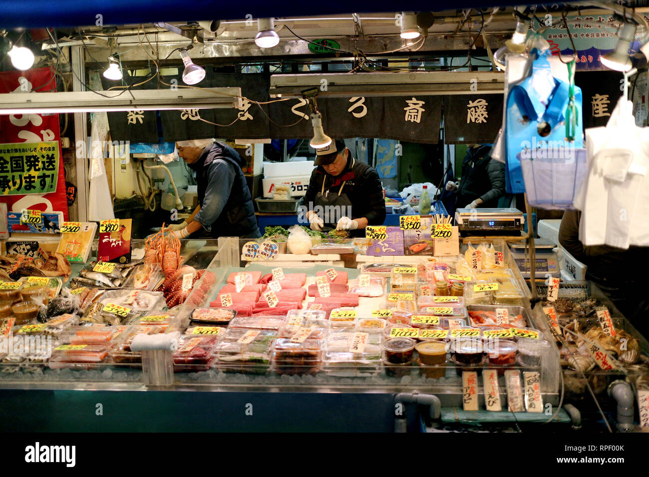 TOYKO, JAPAN - DECEMBER 05, 2016: Unidentified Japanese fish market clerk preparing the fish for the clients in Tsukiji fish market in Toyko, Japan Stock Photo
