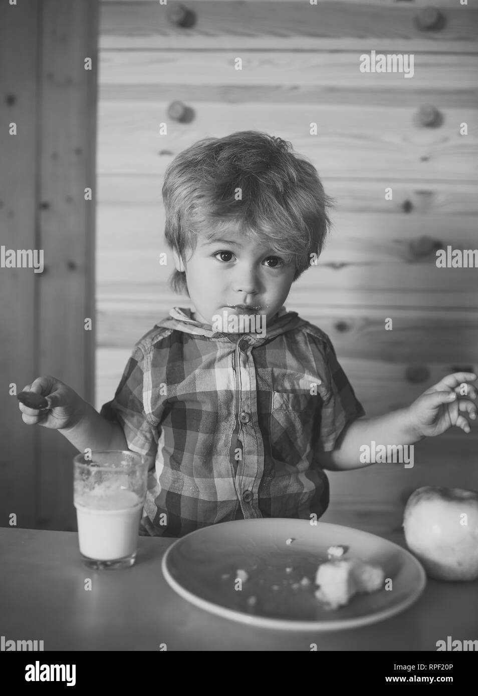 small boy child eating morning breakfast of apple, banana, milk Stock