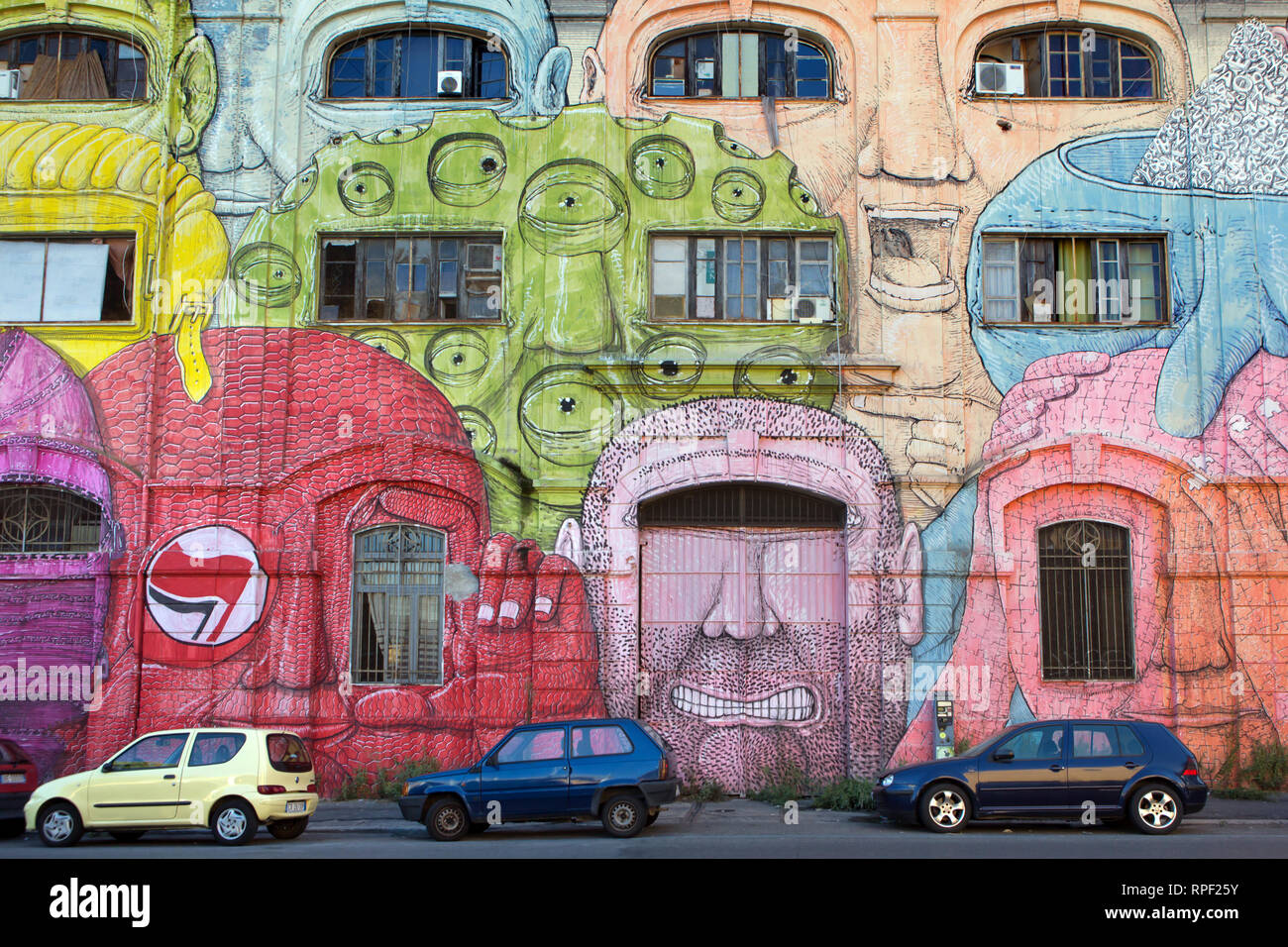 ROME - A squated former military barrack in Ostiense is covered with gigantic alien faces by Italian artist BLU. Stock Photo