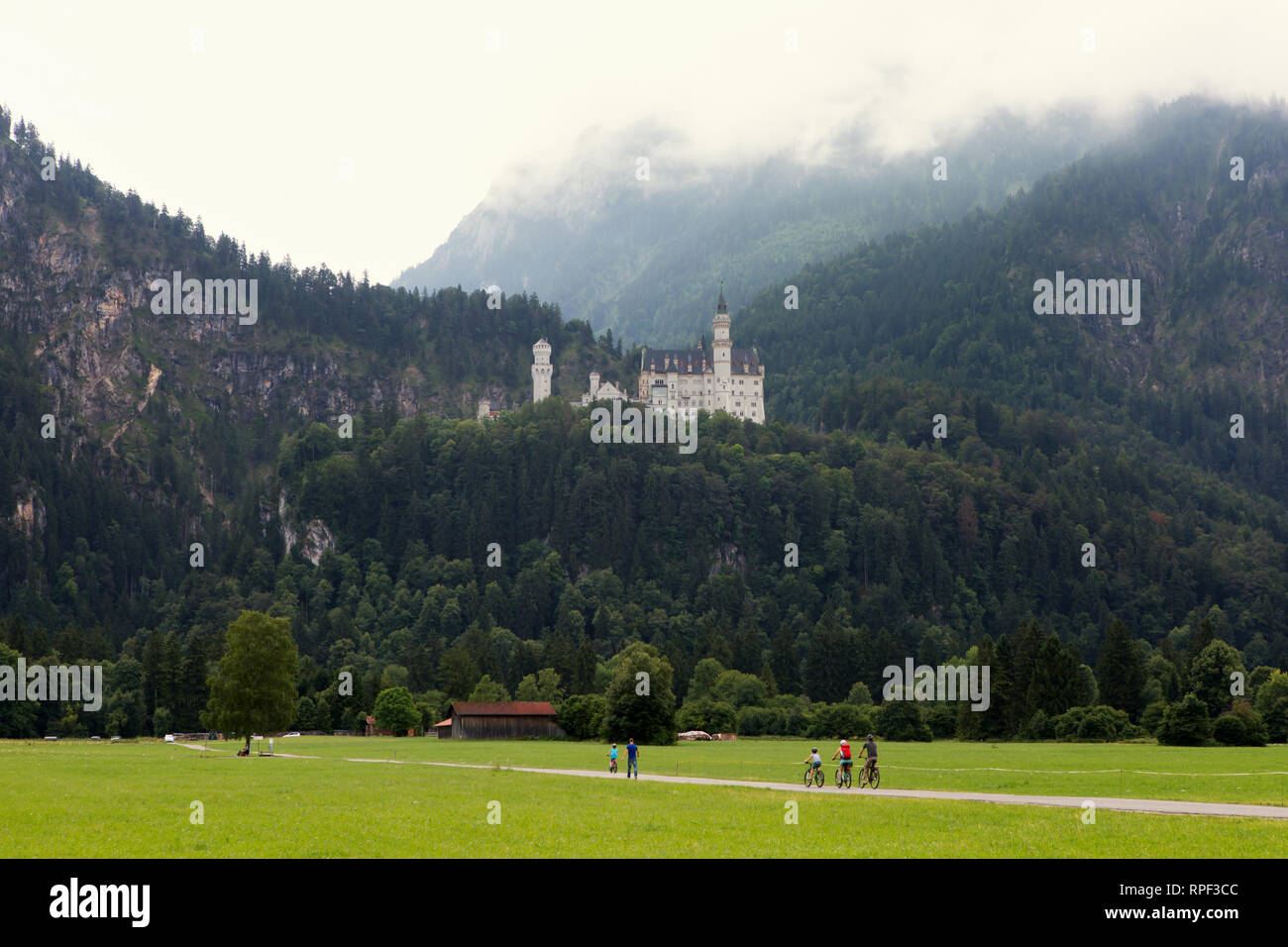 SCHWANGAU - Cyclists with the famous Neuschwanstein castle in the background. Stock Photo